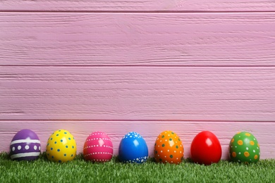 Decorated Easter eggs on green grass. Space for text