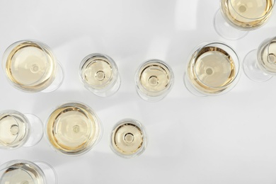 Glass of expensive white wine on light background, top view