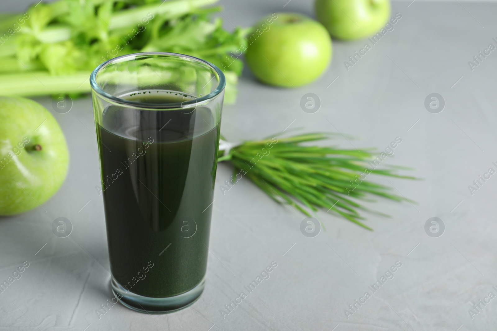 Photo of Glass of spirulina drink on grey background. Space for text