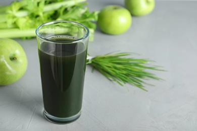 Photo of Glass of spirulina drink on grey background. Space for text