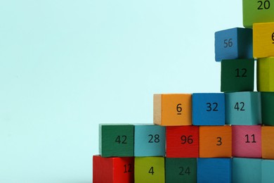Photo of Wooden cubes with different numbers on light background. Space for text