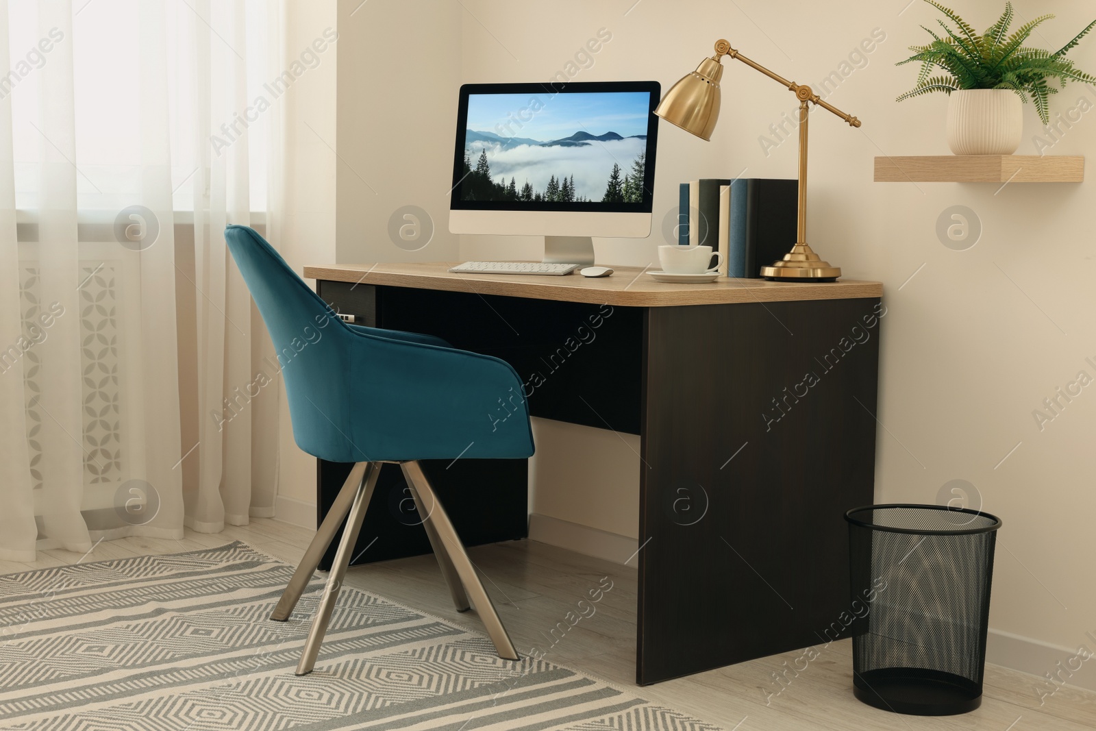 Photo of Cozy workspace with computer on wooden desk and comfortable chair at home