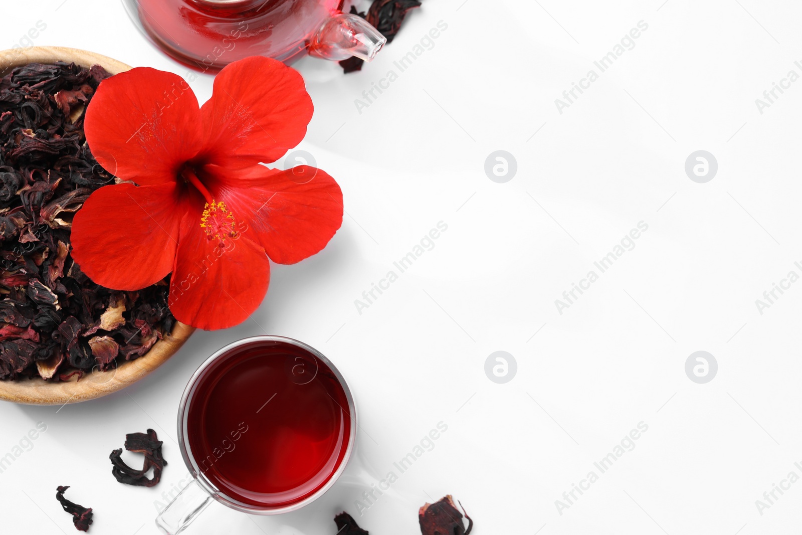 Photo of Delicious hibiscus tea and flowers on white background, flat lay. Space for text