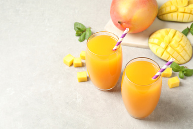 Fresh delicious mango drink on light table. Space for text