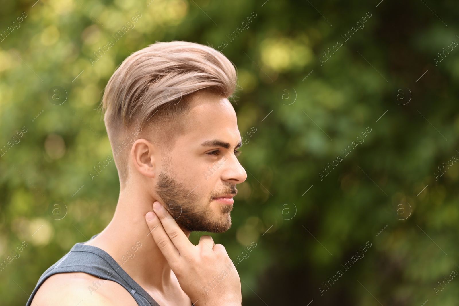 Photo of Young man checking pulse outdoors on sunny day