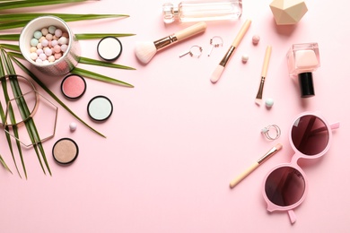 Flat lay composition with products for decorative makeup on pastel pink background