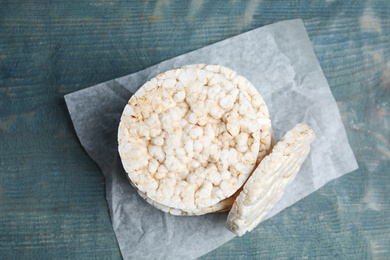 Photo of Stack of crunchy rice cakes on light blue wooden table, top view