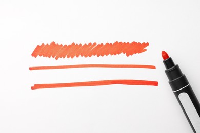 Photo of Different stripes drawn with orange marker and highlighter isolated on white, top view