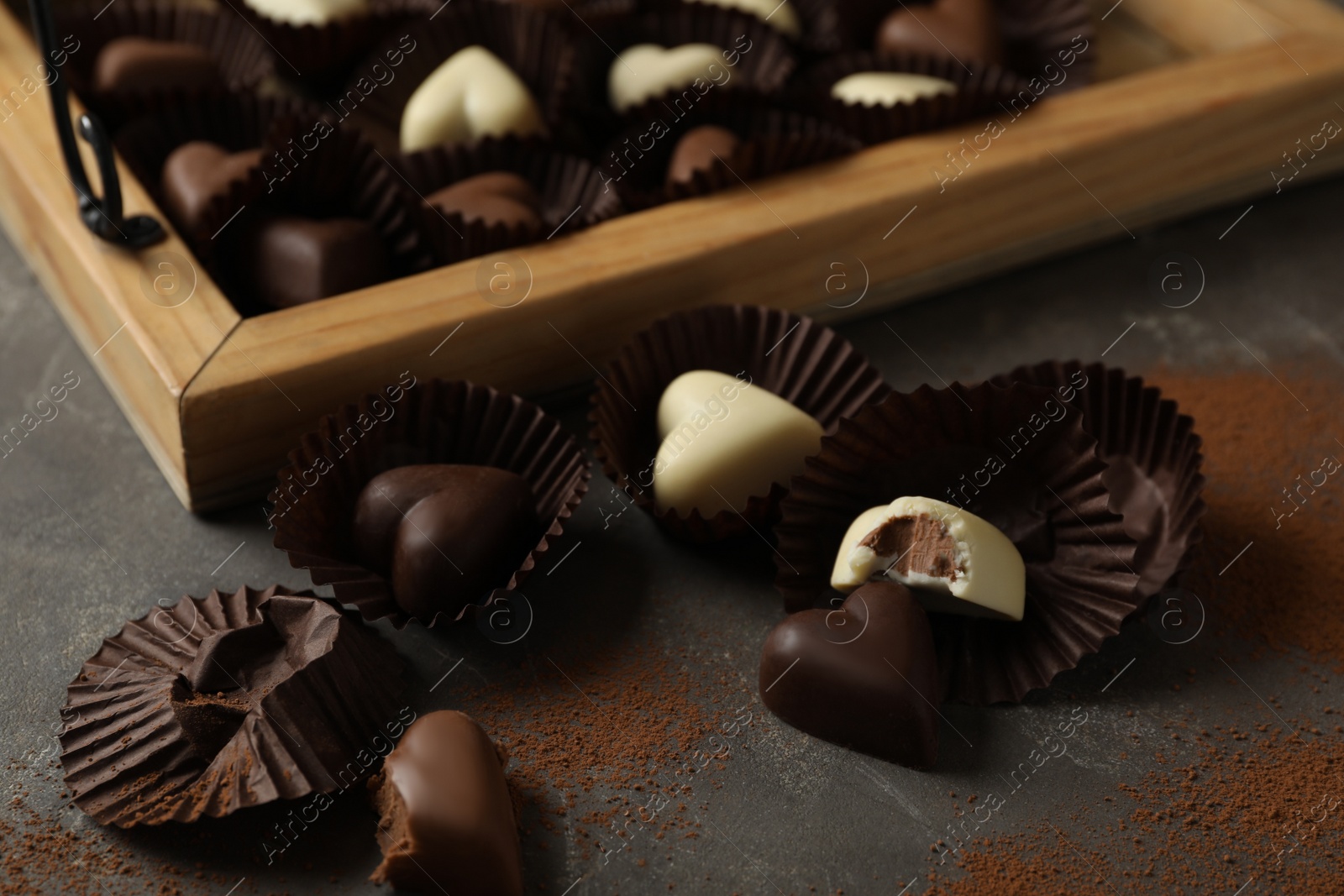 Photo of Beautiful heart shaped chocolate candies on black table