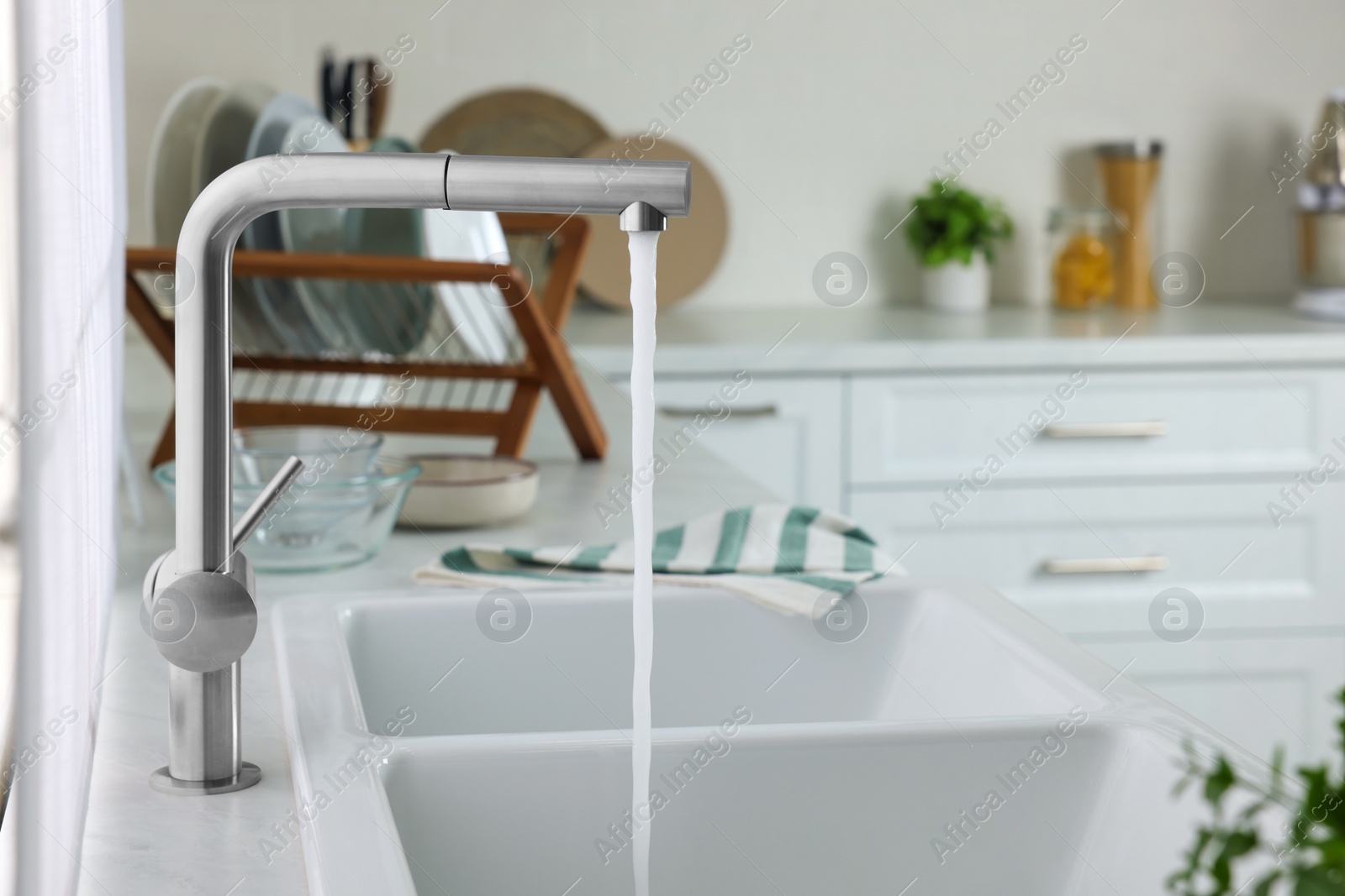 Photo of Stream of water flowing from tap in kitchen, space for text