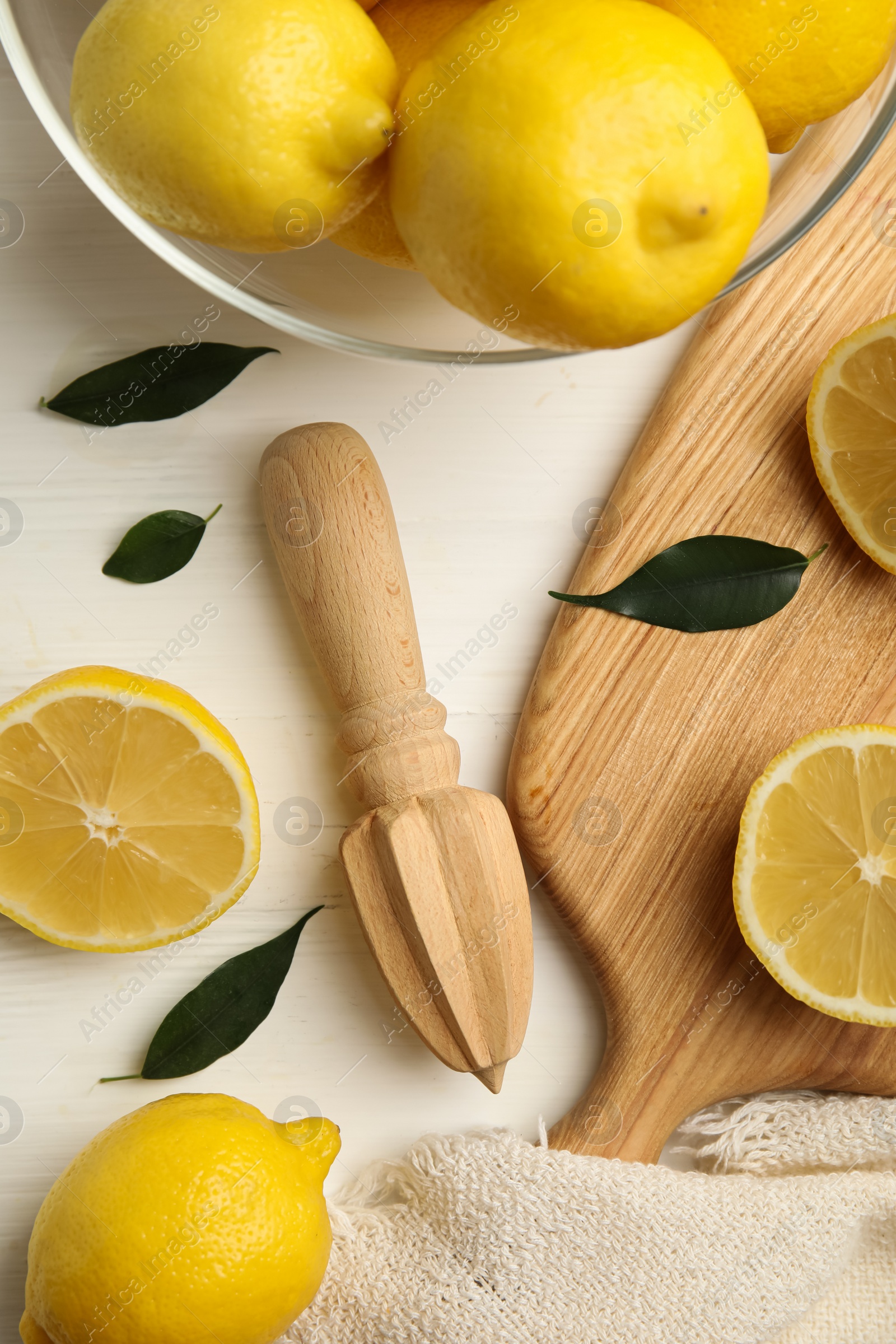 Photo of Citrus reamer and fresh lemons on white wooden table, flat lay