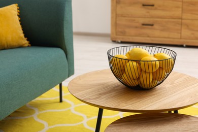 Spring interior. Bowl of lemons on wooden table in living room, space for text