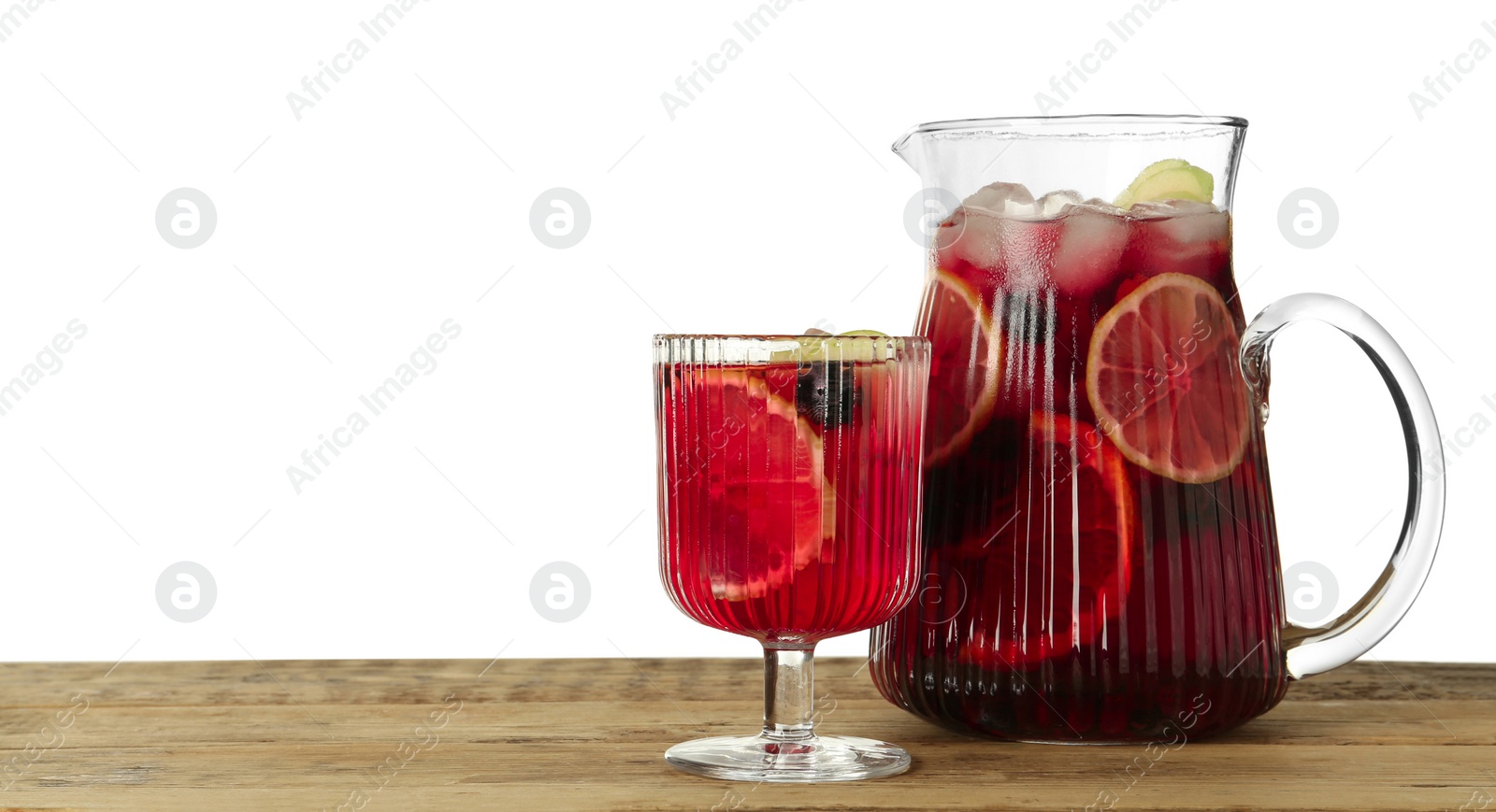 Photo of Glass and jug of Red Sangria on wooden table against white background. Space for text