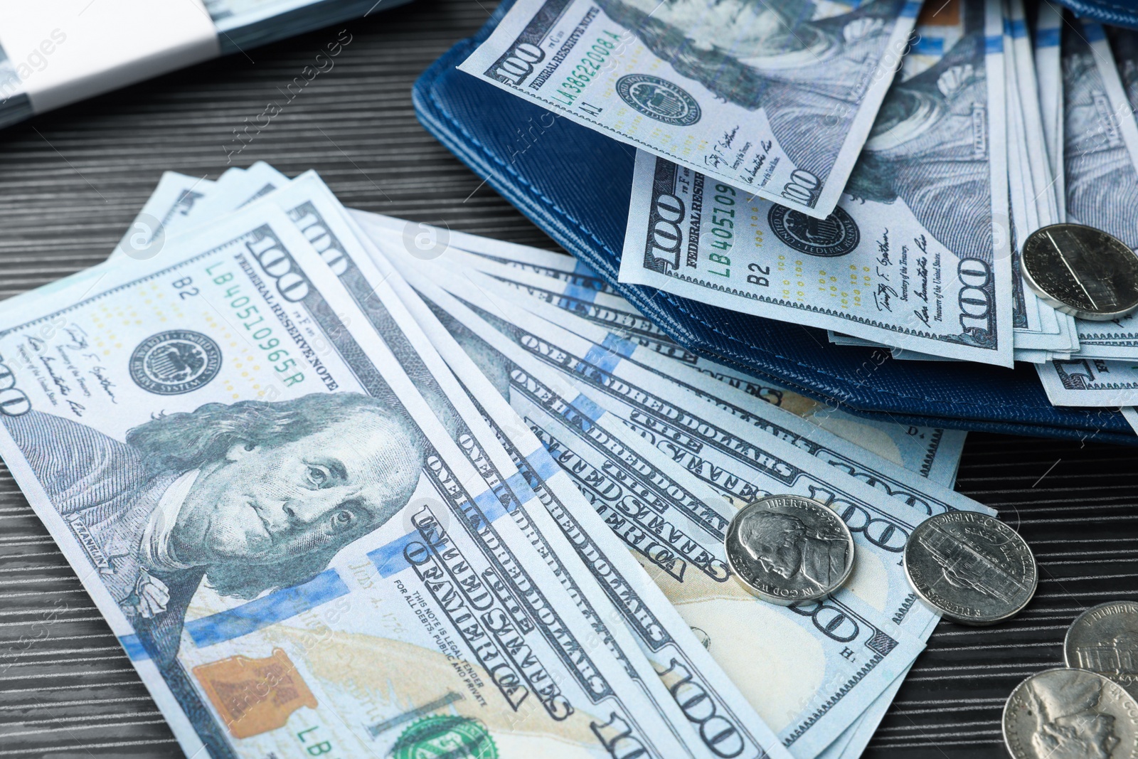 Photo of Dollar banknotes, coins and wallet on black wooden table, closeup. Money exchange