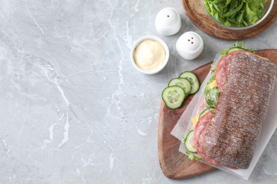 Tasty sandwich with ham on grey table, flat lay. Space for text