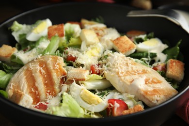 Photo of Delicious Caesar salad in bowl, closeup view