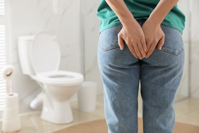 Photo of Woman suffering from hemorrhoid in rest room, closeup