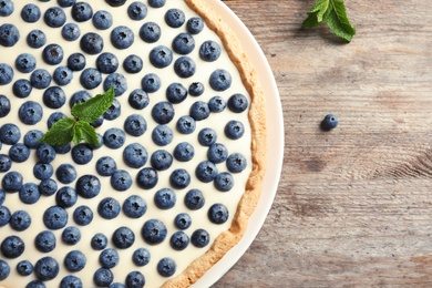Photo of Flat lay composition with tasty blueberry cake and space for text on wooden table