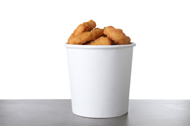 Photo of Bucket with tasty chicken nuggets on grey table against white background