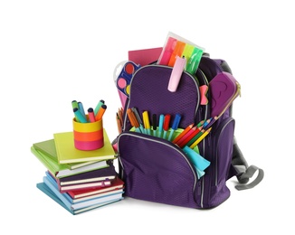 Purple backpack with different school stationery on white background