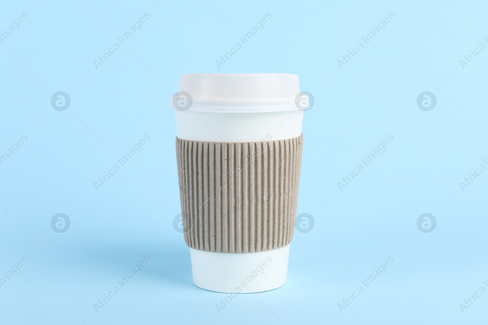 Photo of Paper cup with plastic lid on light blue background. Coffee to go