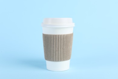 Photo of Paper cup with plastic lid on light blue background. Coffee to go