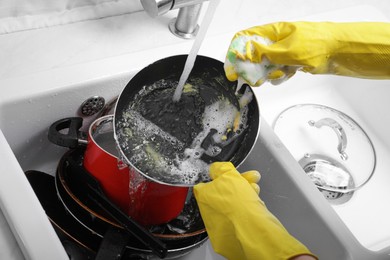 Photo of Woman washing frying pan in kitchen sink, above view