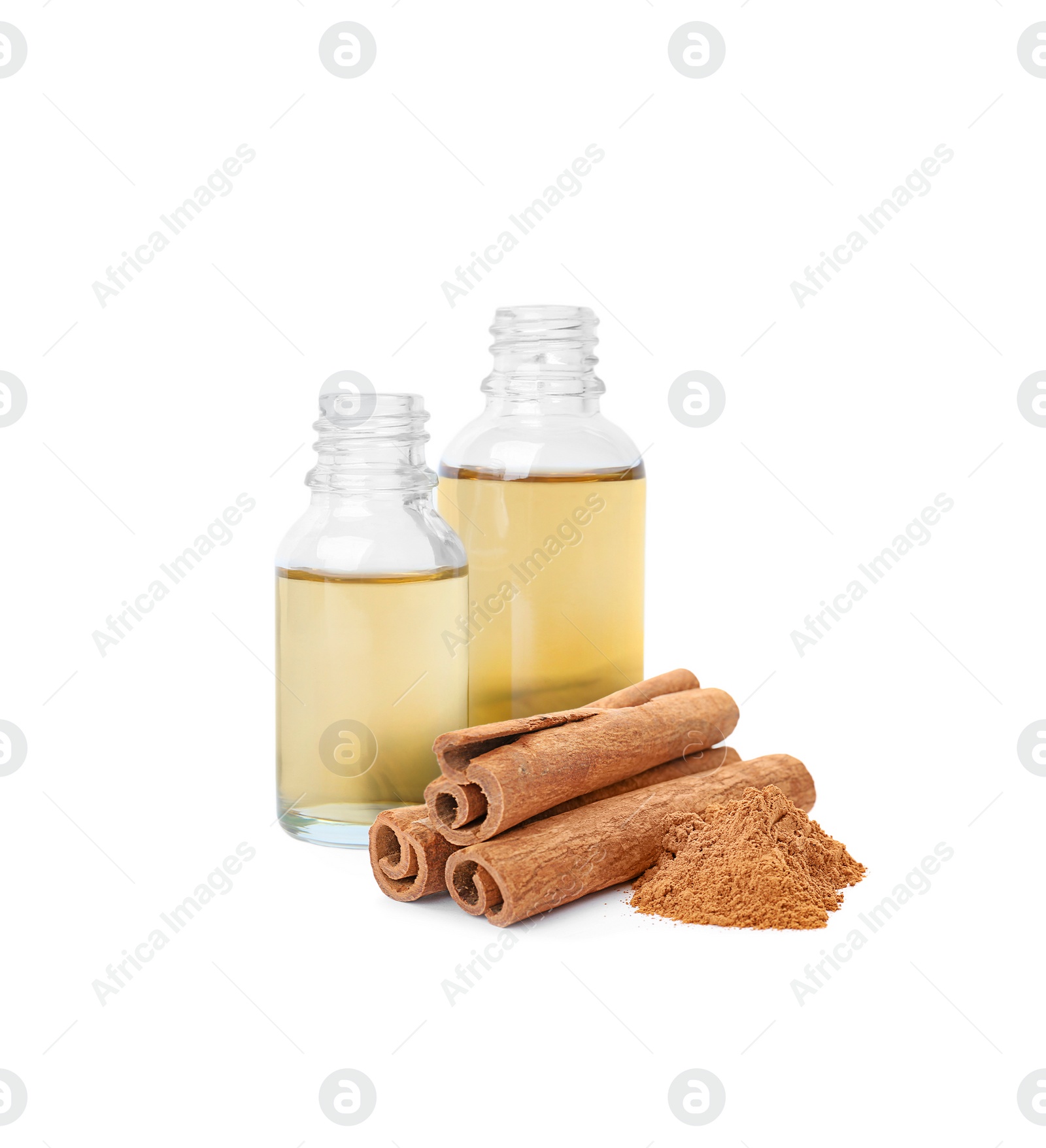 Image of Bottles of natural essential oil, dry cinnamon sticks and powder on white background