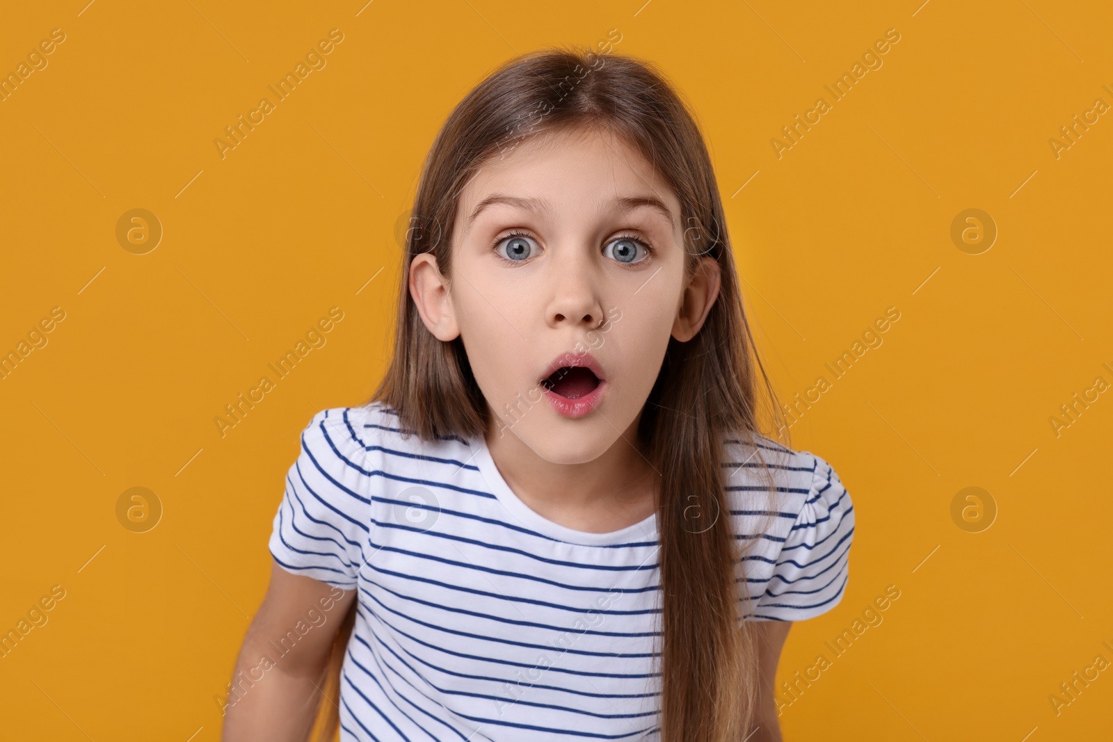 Photo of Portrait of surprised girl on yellow background