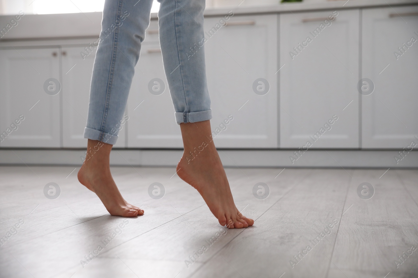 Photo of Barefoot woman at home, closeup. Floor heating system