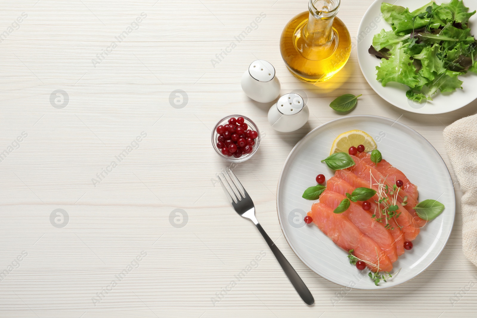 Photo of Delicious salmon carpaccio served on white wooden table, flat lay. Space for text