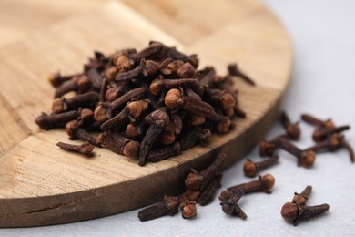 Photo of Pile of aromatic cloves on light table, closeup