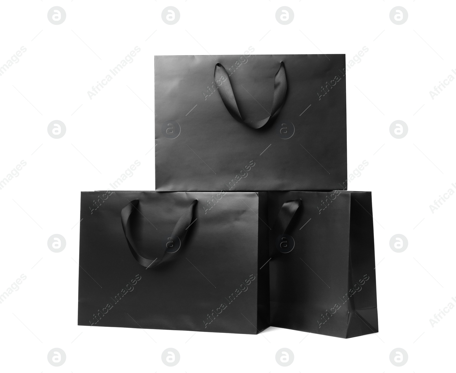 Photo of Paper shopping bags with ribbon handles on white background. Mockup for design