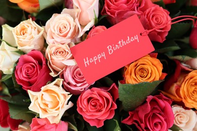 Image of Bouquet of beautiful roses with Happy Birthday card, top view