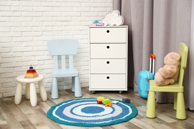 Photo of Modern baby room interior with white chest of drawers