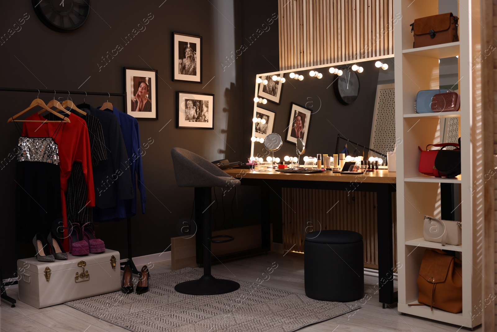 Photo of Chair, clothes rack and stylish mirror on dressing table in makeup room