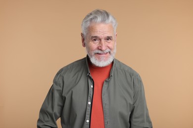 Photo of Portrait of surprised senior man on beige background