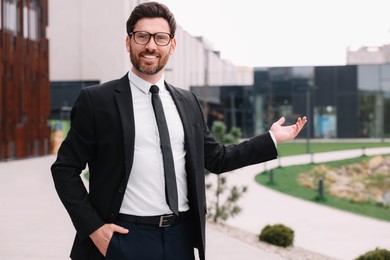 Photo of Handsome male real estate agent in glasses outdoors