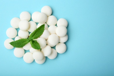 Tasty mint candies and leaves on color background, top view