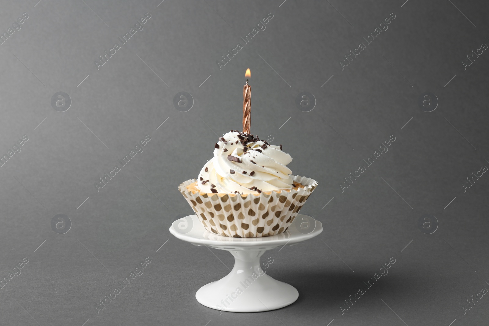Photo of Delicious birthday cupcake with candle on grey background