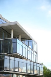 Photo of Modern building with big windows against blue sky outdoors