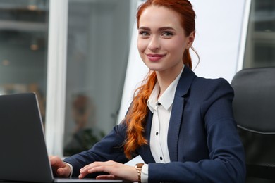 Happy woman working with laptop in office