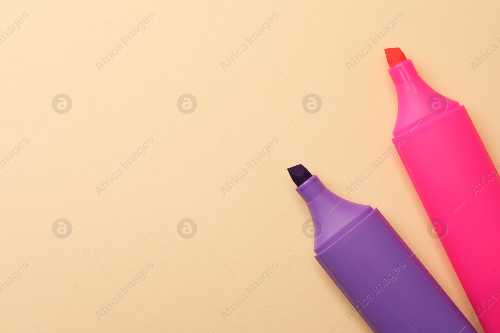 Photo of Bright color markers on beige background, flat lay. Space for text