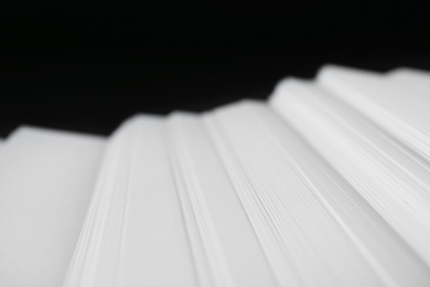 Photo of Stack of blank paper on dark background, closeup