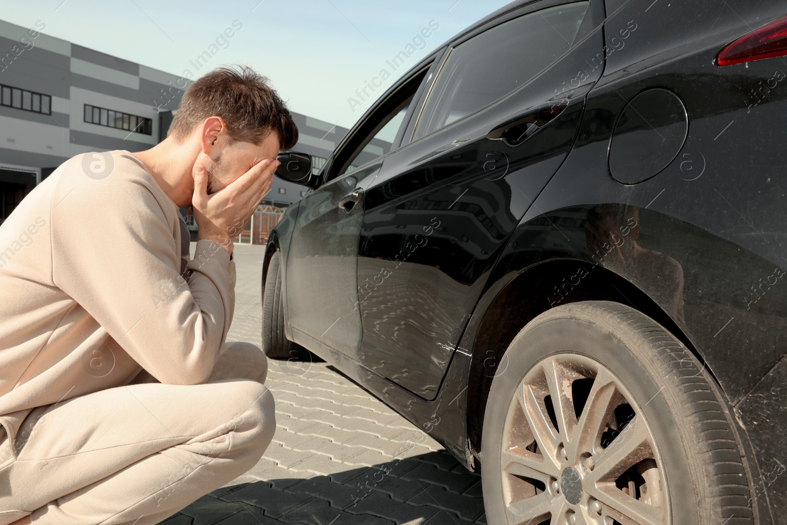 Photo of Stressed man near car with scratch outdoors