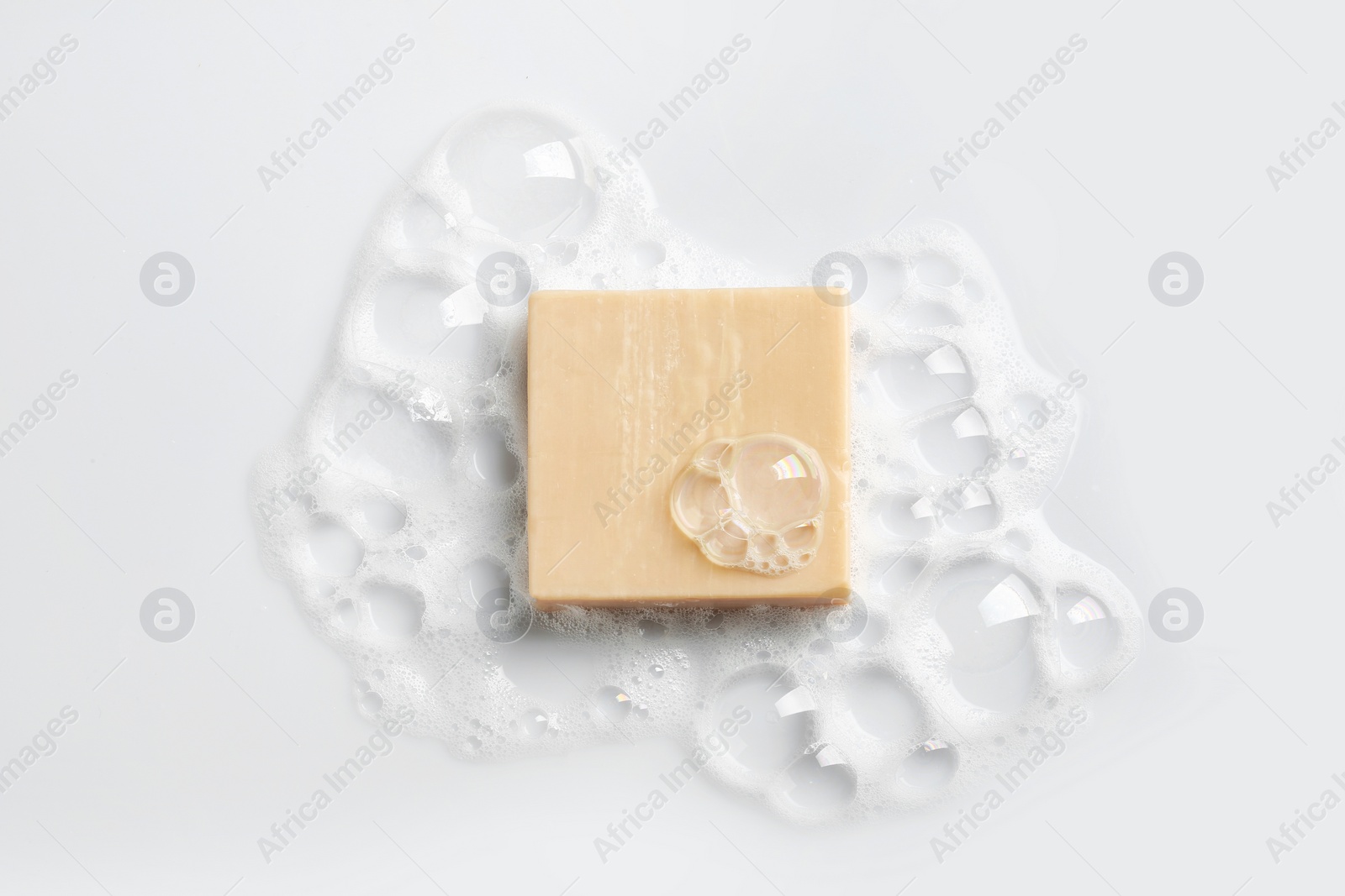 Photo of Soap bar and foam on white background, top view. Mockup for design