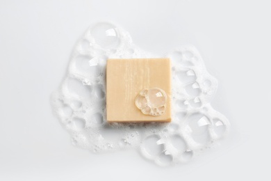 Photo of Soap bar and foam on white background, top view. Mockup for design