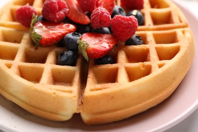 Tasty Belgian waffle with fresh berries on plate, closeup