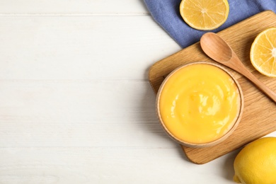 Photo of Delicious lemon curd and fresh fruits on white wooden table, flat lay. Space for text