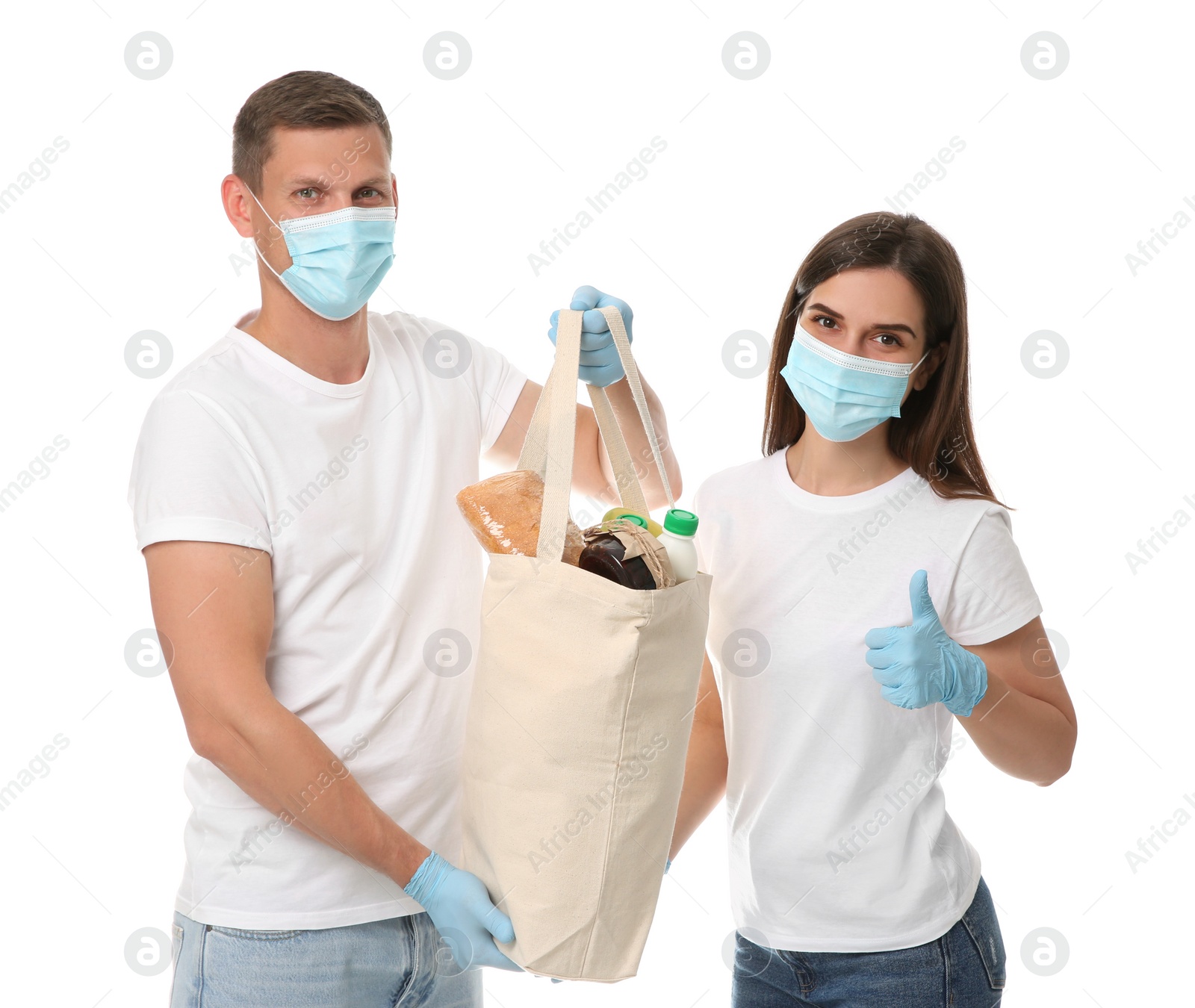 Photo of Volunteers in protective masks and gloves with products on white background. Aid during coronavirus quarantine